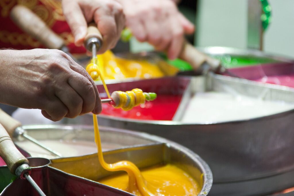 Colorful handmade candies being expertly crafted in professional kitchen, showcasing creativity and skill.