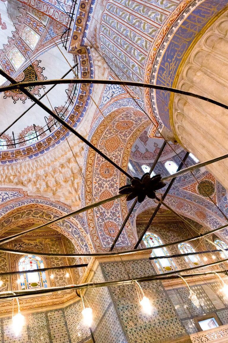 Stunning Islamic mosque interior with intricate dome, chandelier, and mosaic patterns.