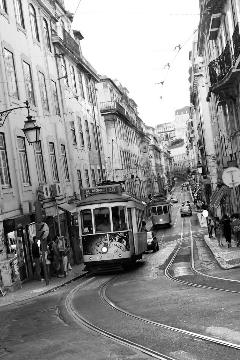 European city street with classic trams, old buildings, pedestrians, and lively urban atmosphere.