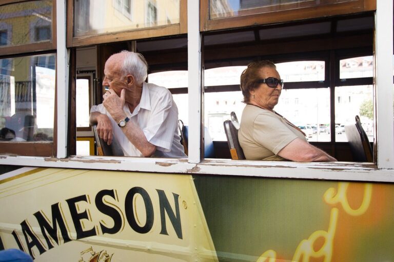 Elderly passengers lost in contemplation on a city tram.
