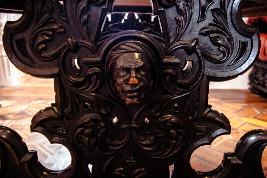 Artisan-Crafted Wooden Chair with Carved Face: Elegant and Detailed Craftsmanship.