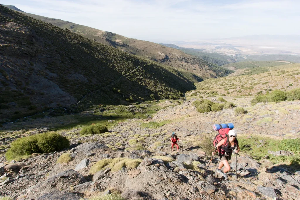 Montañeros subiendo ladera en Sierra Nevada